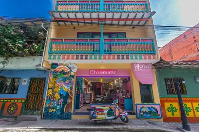 a scooter parked in front of a colorful building at Hotel Chromatic in Guatapé