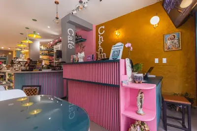 a restaurant with a pink counter and a table at Hotel Chromatic in Guatapé