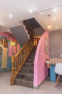 a spiral staircase in a room with pink and purple walls at Hotel Chromatic in Guatapé