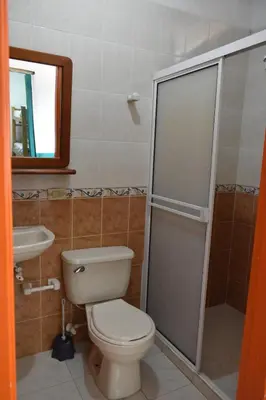 a bathroom with a toilet and a sink and a shower at Origen Hostel Jardín in Jardin
