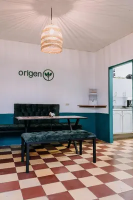 a living room with a bench and a table at Origen Hostel Jardín in Jardin