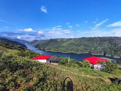 two buildings on a hill next to a river at COCOZNA Glamping in Norcasia