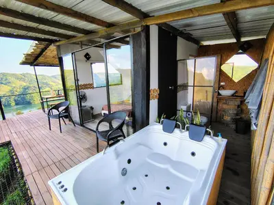 a large bath tub sitting on a deck with chairs at COCOZNA Glamping in Norcasia