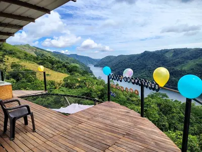 a deck with balloons and a view of a river at COCOZNA Glamping in Norcasia