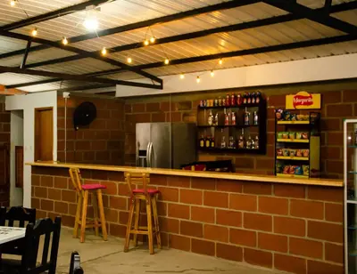 a bar in a restaurant with two stools at CASA HOTEL LOS ARBOLES in Bello