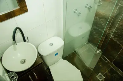 a bathroom with a toilet and a sink and a shower at CASA HOTEL LOS ARBOLES in Bello