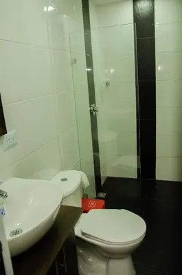 a bathroom with a toilet and a sink at CASA HOTEL LOS ARBOLES in Bello
