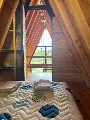 a large bed in a attic with a window at Cabaña Starka & Jacuzzi in Marinilla