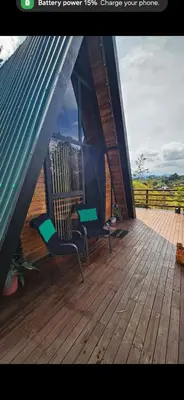 a porch with two chairs and a table on a deck at Cabaña Starka & Jacuzzi in Marinilla
