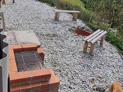 two park benches sitting on a gravel path at Cabaña Starka & Jacuzzi in Marinilla