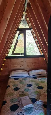 a bed in a room with a window in a attic at Cabaña Starka & Jacuzzi in Marinilla
