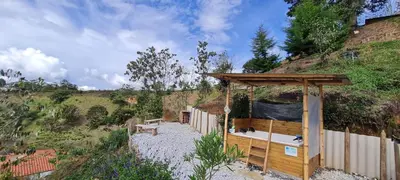 a gazebo with a bench next to a hill at Cabaña Starka & Jacuzzi in Marinilla