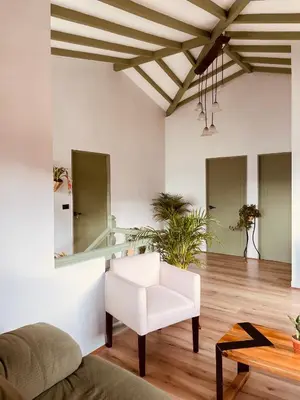a living room with a white chair and a mirror at Hotel Casa Dulces del Jardín in Jardin