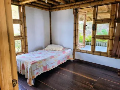 a bedroom with a bed in a room with windows at LA MARQUESA PACORA in Pácora