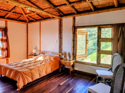 a bedroom with a bed in a room with windows at LA MARQUESA PACORA in Pácora