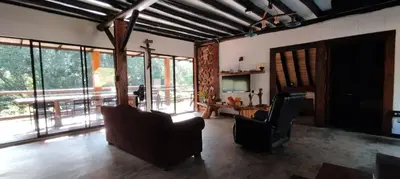 a living room with chairs and a table and windows at Isla Escondida Maceo Finca Hotel y Restaurante in Yolombó