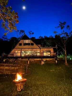 a fire in front of a house at night at Isla Escondida Maceo Finca Hotel y Restaurante in Yolombó
