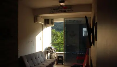 a living room with a couch and a balcony at Hakuna Matata in San Jerónimo