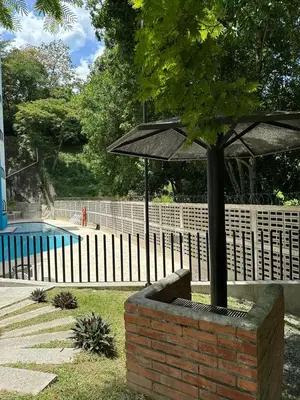 a brick planter with an umbrella next to a pool at Hakuna Matata in San Jerónimo