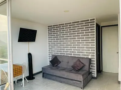 a couch in a living room with a brick wall at ¡Vista Increíble Apartamento Tamarindo! in Santa Fe de Antioquia