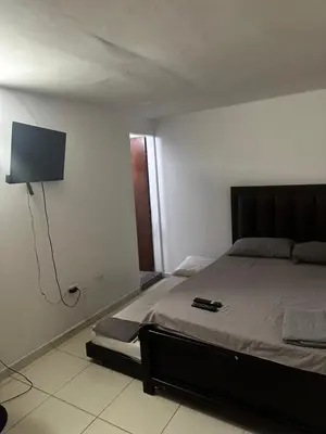 a bedroom with a bed and a flat screen tv at APARTAMENTO LAURELES ESTADIO NUEVO in Medellín