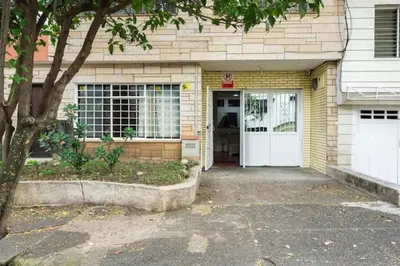a yellow brick house with a white door at Casa Laura in Medellín