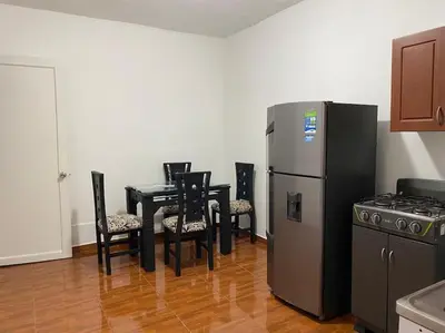 a kitchen with a table and chairs and a refrigerator at Casa Laura in Medellín