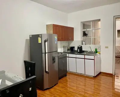 a kitchen with a stainless steel refrigerator and cabinets at Casa Laura in Medellín