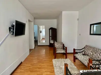 a living room with two chairs and a television on a wall at Casa Laura in Medellín