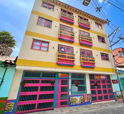 a building with colorful doors and windows on a street at Apto cerca Malecón, Plaza Principal, Plazoleta Zocalos, a 8 min de la Piedra del Peñol, GRATIS PARQUEADERO!!! in Guatapé