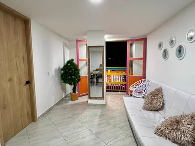 a living room with a couch and a mirror at Apto cerca Malecón, Plaza Principal, Plazoleta Zocalos, a 8 min de la Piedra del Peñol, GRATIS PARQUEADERO!!! in Guatapé