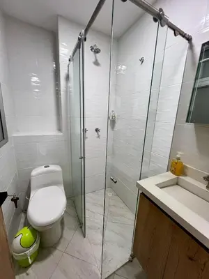 a bathroom with a toilet and a glass shower at Apto cerca Malecón, Plaza Principal, Plazoleta Zocalos, a 8 min de la Piedra del Peñol, GRATIS PARQUEADERO!!! in Guatapé