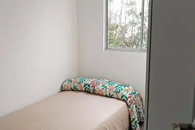 a small bed in a room with a window at Semi-loft Manizales Colombia in Manizales
