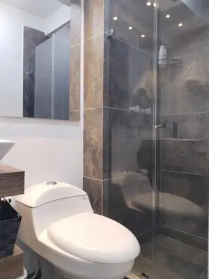 a bathroom with a toilet and a glass shower at Semi-loft Manizales Colombia in Manizales