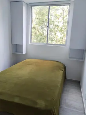 a bed in a room with a window at Semi-loft Manizales Colombia in Manizales