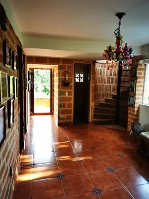 a hallway with a tile floor and a staircase at Finca con forma de castillo y piscina en Sopetrán in Sopetran