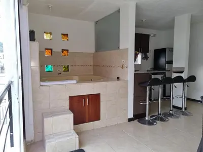 a kitchen with a tub and some bar stools at Apartasol Ciudadela Santafe in Santa Fe de Antioquia