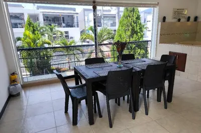 a black dining room table with black chairs and a balcony at Apartasol Ciudadela Santafe in Santa Fe de Antioquia