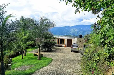 a house with a car parked in the driveway at Piscina-gran vista-clima cálido y pueblo histórico in Santa Fe de Antioquia