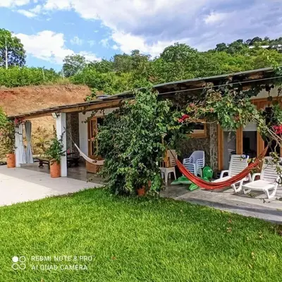 a house with chairs and a hammock in the yard at Piscina-gran vista-clima cálido y pueblo histórico in Santa Fe de Antioquia