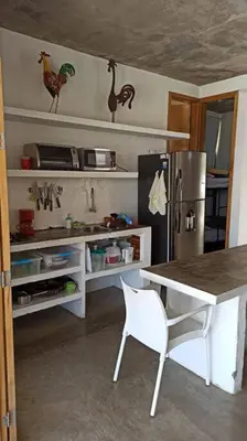 a kitchen with a table and a refrigerator at Piscina-gran vista-clima cálido y pueblo histórico in Santa Fe de Antioquia