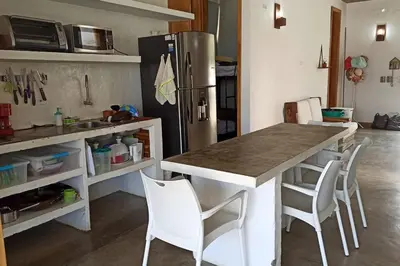 a kitchen with a table and chairs and a refrigerator at Piscina-gran vista-clima cálido y pueblo histórico in Santa Fe de Antioquia