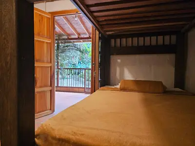 a bedroom with a bed and a sliding glass door at Pradera Ecoliving in Betania