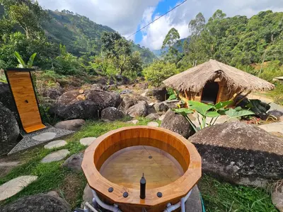 a wooden fire pit in a field with a hut at Pradera Ecoliving in Betania