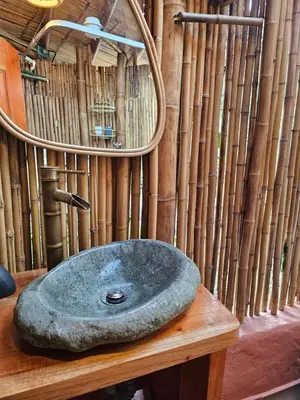 a bathroom with a stone sink on a wooden table at Pradera Ecoliving in Betania