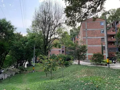 a park in a city with a building and trees at Acogedor Apartamento Urbanización Tricentenario in Medellín