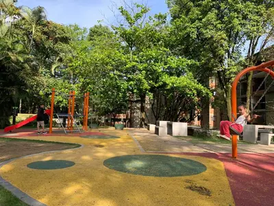 a young child is sitting on a playground at Acogedor Apartamento Urbanización Tricentenario in Medellín