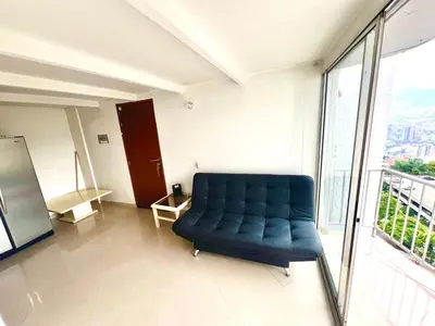a blue couch in a room with a window at Medellin parque lleras poblado palmas in Medellín