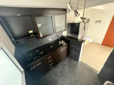 a kitchen with black counters and a stove top oven at Medellin parque lleras poblado palmas in Medellín