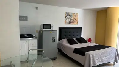 a bedroom with a bed and a glass table at Apartaestudio Cerca a los Molinos in Medellín